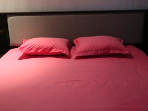 two pink pillows sitting on top of a bed at Appartment Central Hammam Sousse plage in Sousse