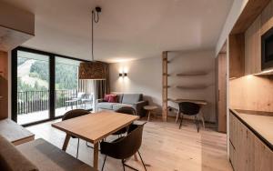 a kitchen and living room with a table and chairs at Residence Le Fostü in San Vigilio Di Marebbe