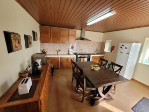uma cozinha com uma mesa e cadeiras e um frigorífico em Casa Fagundes em Faja Grande
