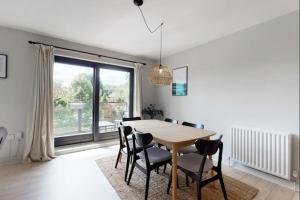a dining room with a table and chairs and a window at Modern 2 bedroom flat with patio in Turnpike Lane in London