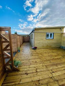 a wooden deck next to a building with a fence at Studio 41 in Eppeville