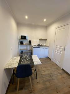 eine kleine Küche mit einem Tisch mit Weingläsern darauf in der Unterkunft Studio 41 in Eppeville