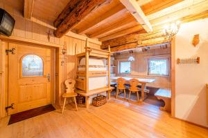 een slaapkamer met een stapelbed en een tafel en stoelen bij Chalet Sottoguda in Rocca Pietore