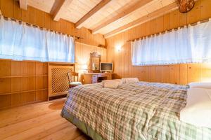een slaapkamer met een bed in een kamer met houten wanden bij Chalet Sottoguda in Rocca Pietore