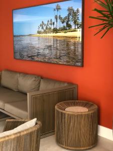 a living room with a couch and a tv on a wall at Apartamento em Guarajuba, BAHIA 2 Tudo Novinho e Finamente Decorado in Camaçari