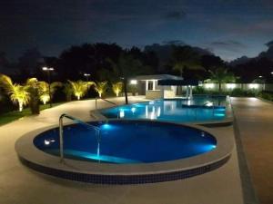 una gran piscina por la noche con luces. en Apartamento em Guarajuba, BAHIA 2 Tudo Novinho e Finamente Decorado, en Camaçari
