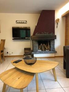 sala de estar con mesa y chimenea en La gentiane, en Grimentz