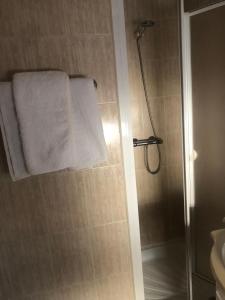 a bathroom with a shower with a white towel at Hostal De La Rosa in Valdemoro