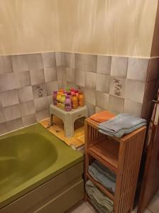 a bathroom with a tub and a table with towels at Chambre d'hôte in Allouagne
