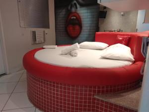 ein großes rotes Bett in einem Zimmer mit rotem Kopfteil in der Unterkunft Hotel 1001 Prime - Ceilândia in Brasilia