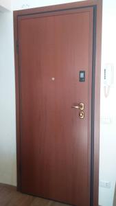 eine braune Tür mit Messinggriff in einem Zimmer in der Unterkunft Aganoor in Padua