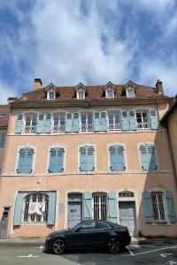 a black car parked in front of a building at Le 32-GregIMMO-Appart'Hôtel in Montbéliard