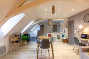 a kitchen and living room with a table and chairs at Le 32-GregIMMO-Appart'Hôtel in Montbéliard