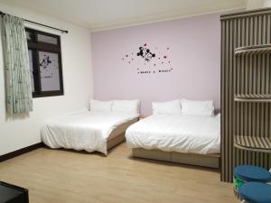 2 Betten in einem Zimmer mit weißen Wänden in der Unterkunft Fuzhongju Homestay in Jincheng