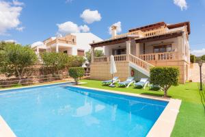 a villa with a swimming pool in front of a house at Buenavista in Portocolom