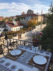 a table with plates of food on a balcony at Capiedra Hotel in Uchisar