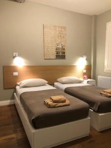 a bedroom with two beds with towels on them at Leon Rosso Flat in Florence