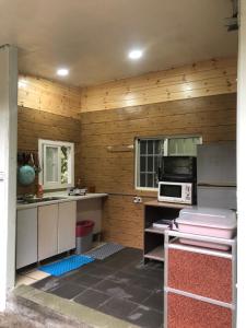 uma cozinha com paredes de madeira e um forno com placa de fogão em Xijing Ecological Farm em Hualing