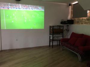 a living room with a large projection of a soccer game at El nido del Rusiñol in Cervera de Pisuerga