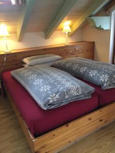 2 almohadas en una cama de madera en una habitación en Cèsa Prà da Molin, en Campitello