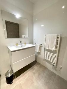 Baño blanco con lavabo y espejo en Appartement 1 chambre Monte Stella, en Monticello