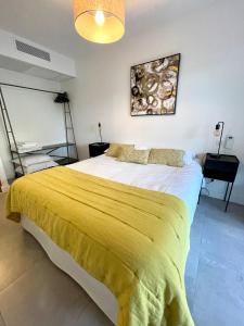 1 dormitorio con 1 cama grande con manta amarilla en Appartement 1 chambre Monte Stella, en Monticello