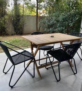 una mesa de madera y 4 sillas alrededor de una mesa y sillas de madera en Appartement 1 chambre Monte Stella, en Monticello