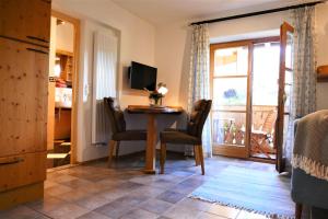 a living room with a table and chairs and a balcony at Ferienwohnung Goller in Lenggries