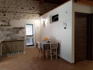 eine Küche und ein Esszimmer mit einem Tisch und Stühlen in der Unterkunft Casa vacanze Krimisòs in Castellammare del Golfo