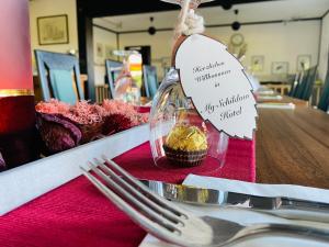 einen Tisch mit Gabel und einen Teller mit Cupcake in der Unterkunft Hotel My Schildow in Schildow