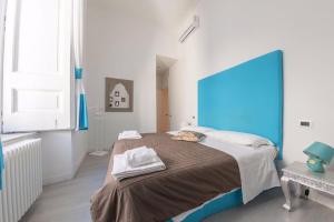 a bedroom with a large bed with a blue headboard at B&B Neapolis Bellini in Naples