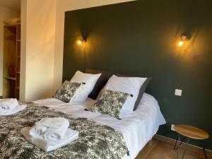 a bedroom with a bed with towels on it at Ty Kervaillet,Maison rénovée proche plage in Névez