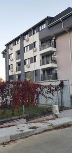 ein großes Apartmenthaus mit einem Zaun davor in der Unterkunft Căsuța din Copou in Iaşi