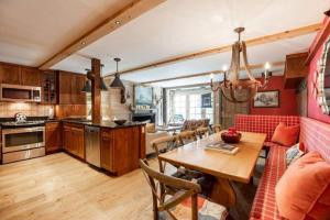 a kitchen and living room with a table and a couch at House Steps to Gondola and Vail Village in Vail