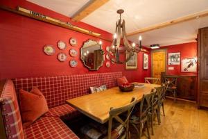 a dining room with a table and a red wall at House Steps to Gondola and Vail Village in Vail