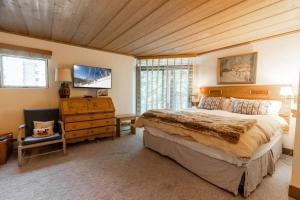 a bedroom with a large bed and a wooden ceiling at House Steps to Gondola and Vail Village in Vail