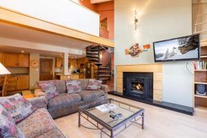 a living room with a couch and a fireplace at Condo with Hot Tub Free Garage Parking in Vail