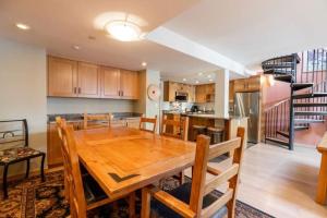 a kitchen and dining room with a wooden table at Condo with Hot Tub Free Garage Parking in Vail