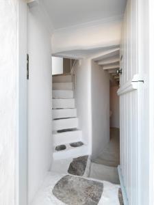 a staircase in a white house with white walls at The Windmill Kimolos in Kimolos