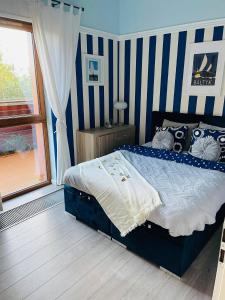 a bedroom with a bed with blue and white stripes at Apartament Marina in Dziwnówek