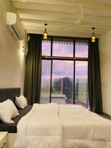 a bedroom with a bed and a large window at Mountain N Lake Resort in Igatpuri