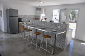 a kitchen with a island with bar stools in it at Villa Salem Maison d'architecte toute équipée & piscine in Arkou