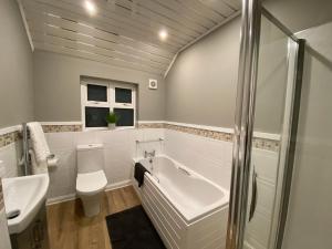 a bathroom with a tub and a toilet and a sink at Durham Road - Zillo in Spennymoor