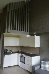 a small kitchen with white cabinets and a couch at 15-Nasjonalpark, sykling, fisking, kanopadling, skogs- og fjellturer in Ljørdal