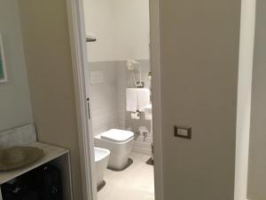 un bagno bianco con un water e un lavandino di The Brilliant Place a Napoli Altre 12 foto