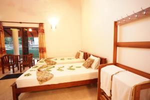
a bedroom with two beds and a table at Vaana Resort in Habarana
