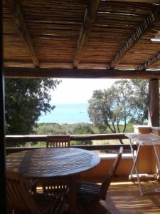 un tavolo e sedie su una veranda con vista sull'oceano di Residence Spiaggia Bianca a Golfo Aranci