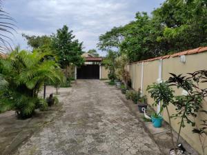 a driveway leading to a garage with trees and plants at Pedacinho do céu in Cabo Frio
