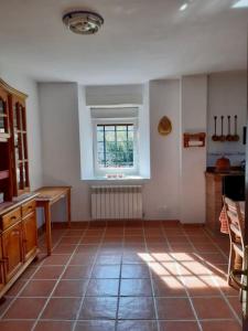 a kitchen with a tile floor and a window at Solar del Huyo in San Mamés de Meruelo