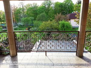 a balcony with an iron gate with a view of a park at Rodinná izba Stummer in Topoľčany
